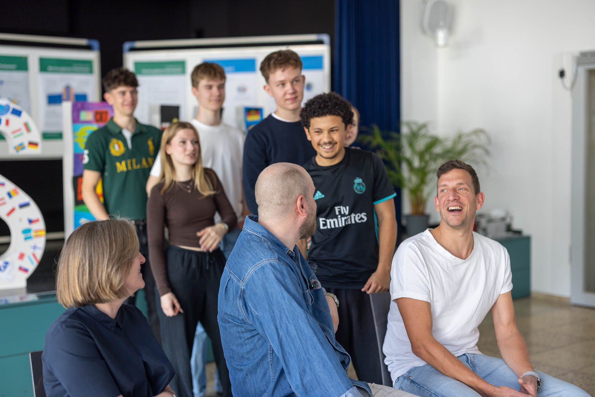 Schüler:innen und Lehrkräfte lachen gemeinsam